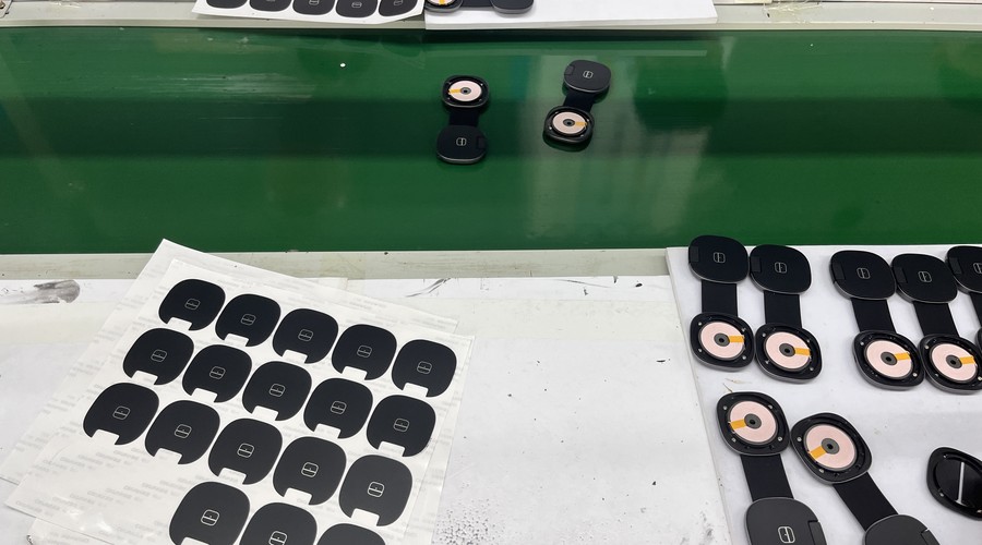 Finished GREENPORT 3-in-1 charger housings and coil modules staged on the assembly line