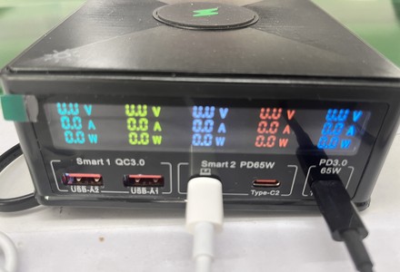 Multi-port power meter showing voltage current and wattage during wireless charger electrical test