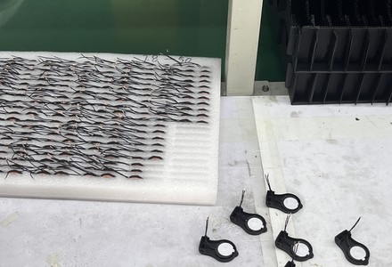 Trays of wound Litz-wire transmit coils with tinned leads before assembly