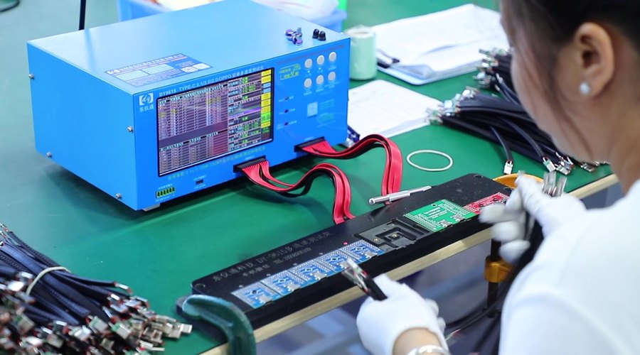 Operator running finished cables on a multi-channel function test fixture