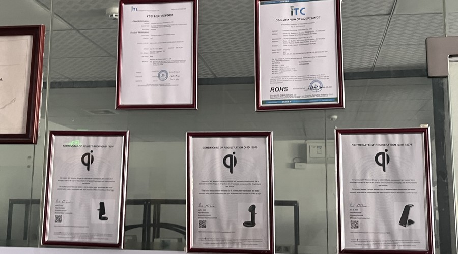 Qi registration certificates, FCC test report and RoHS declaration displayed on the plant wall
