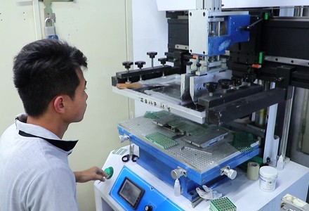 Operator loading a stencil into the solder paste printer for connector PCB panels