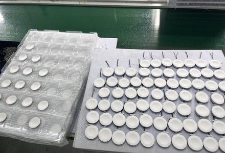 Ferrite shield discs in blister trays next to coils awaiting bonding